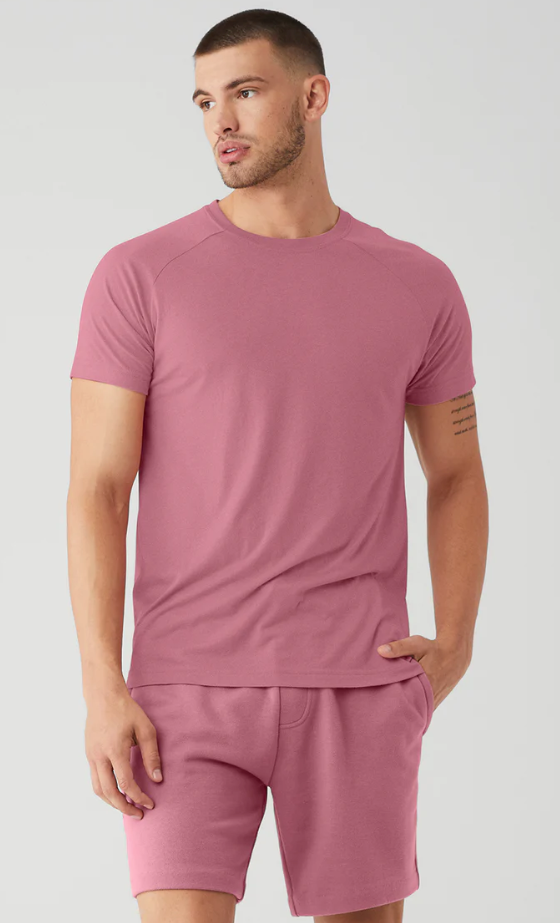 A man wearing a red Alo Yoga t-shirt and matching yoga shorts
