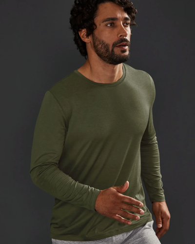 A man wearing a tight-fitting green Beyond Yoga athletic long-sleeve