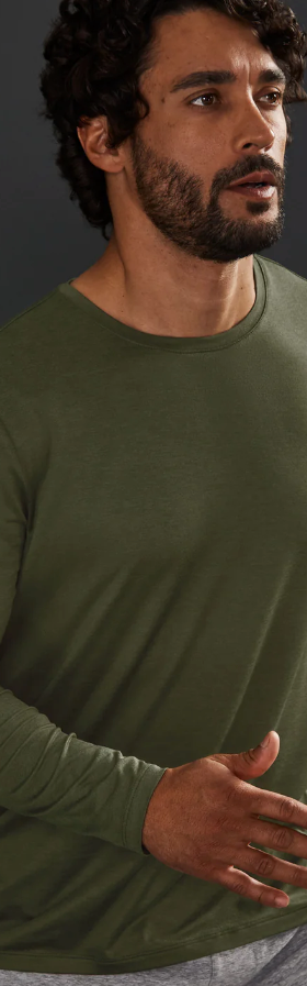 A man wearing a tight-fitting green Beyond Yoga athletic long-sleeve