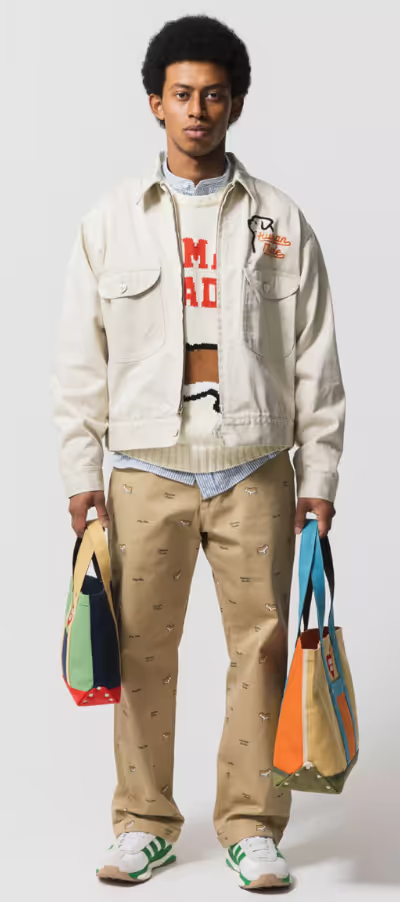 A man wearing a layered Human Made outfit featuring a cream jacket and brown patterned pants