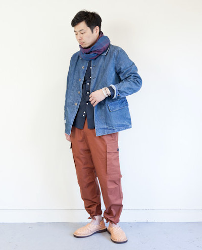 A man wearing a Chimala outfit feating a denim coat and red pants