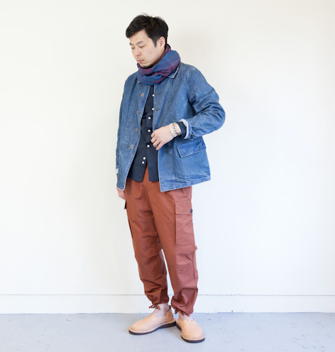 A man wearing a Chimala outfit feating a denim coat and red pants