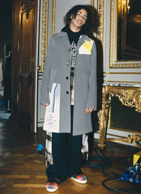 A man wearing a Lanvin overcoat with a hoodie underneath