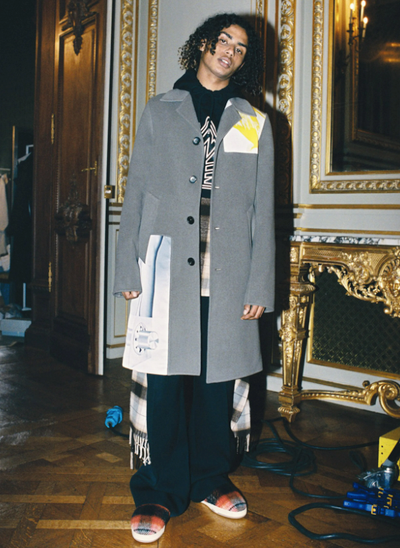 A man wearing a Lanvin overcoat with a hoodie underneath