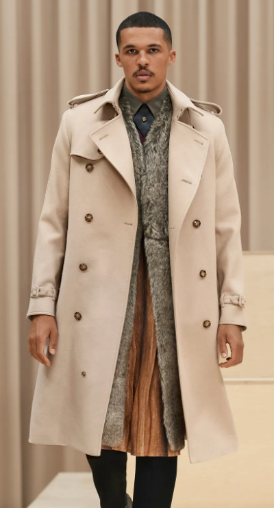 A man wearing a light brown Burberry trench coat with a large floral jacket underneath