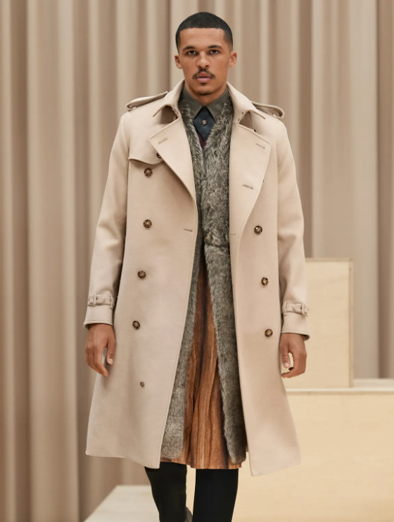 A man wearing a light brown Burberry trench coat with a large floral jacket underneath