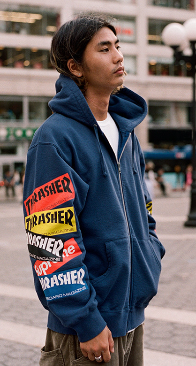 A man wearing a Thrasher Supreme Collaboration hoodie in dark blue