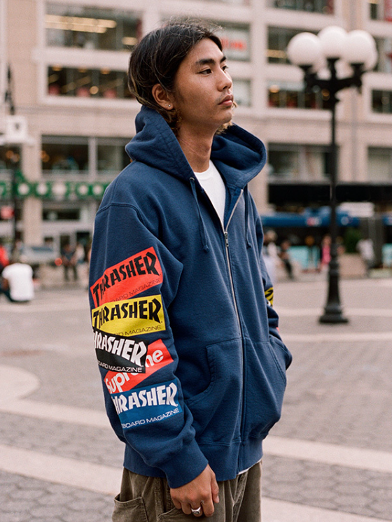A man wearing a Thrasher Supreme Collaboration hoodie in dark blue