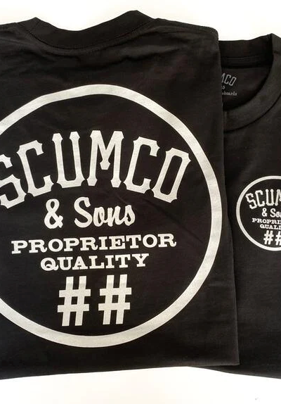 A close of of a Scumco & Sons t-shirt in dark grey with white text