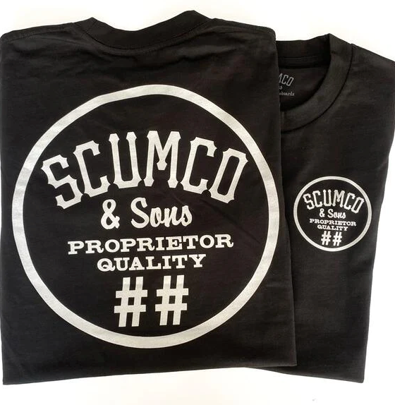 A close of of a Scumco & Sons t-shirt in dark grey with white text