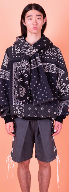 A man wearing a Kapital jacket with a black bandana print and shorts