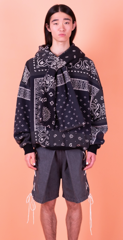 A man wearing a Kapital jacket with a black bandana print and shorts