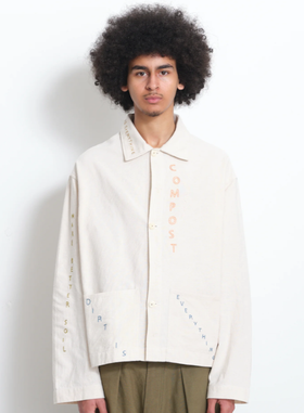 A man wearing a beige Story Mfg jacket with stitching across it