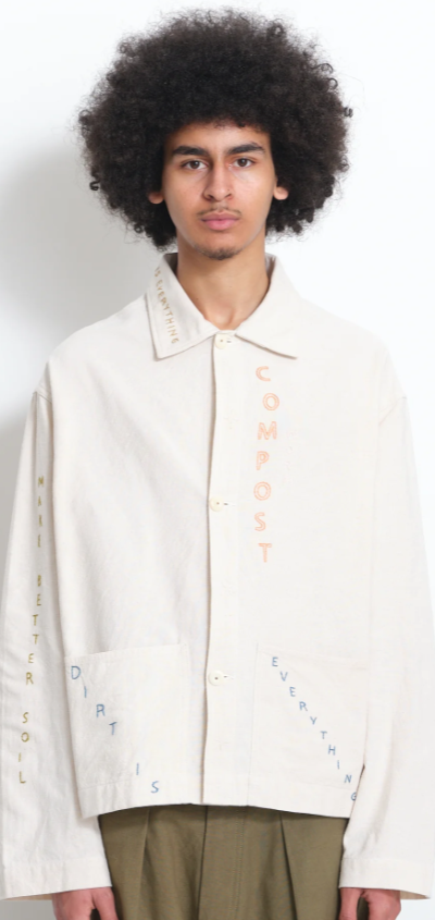 A man wearing a beige Story Mfg jacket with stitching across it