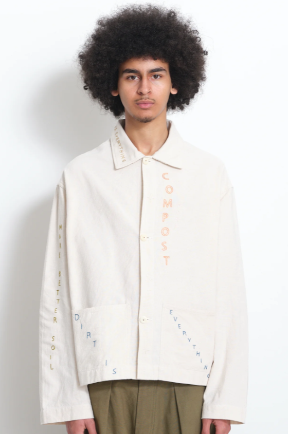 A man wearing a beige Story Mfg jacket with stitching across it