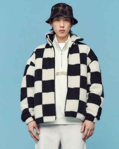 A man wearing a checkered H&M fleece jacket with a plaid bucket hat