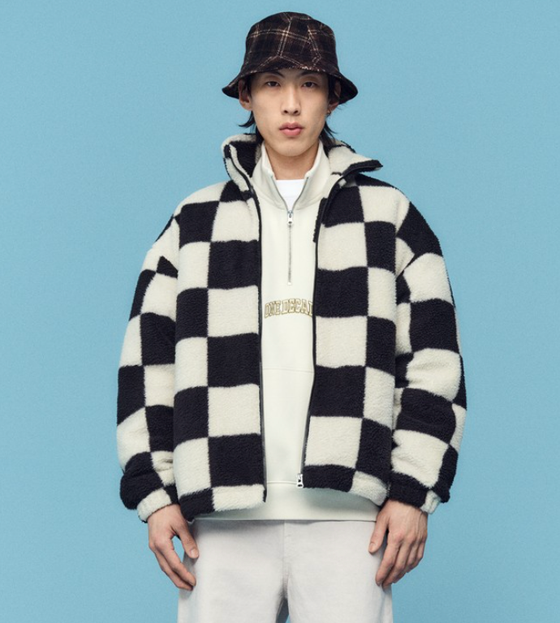 A man wearing a checkered H&M fleece jacket with a plaid bucket hat