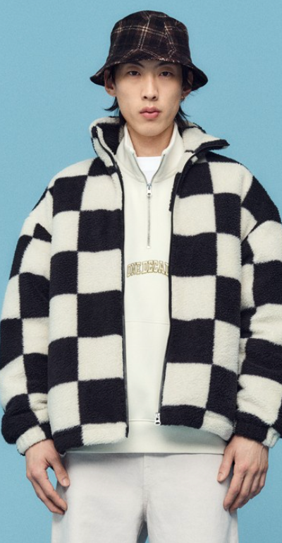 A man wearing a checkered H&M fleece jacket with a plaid bucket hat