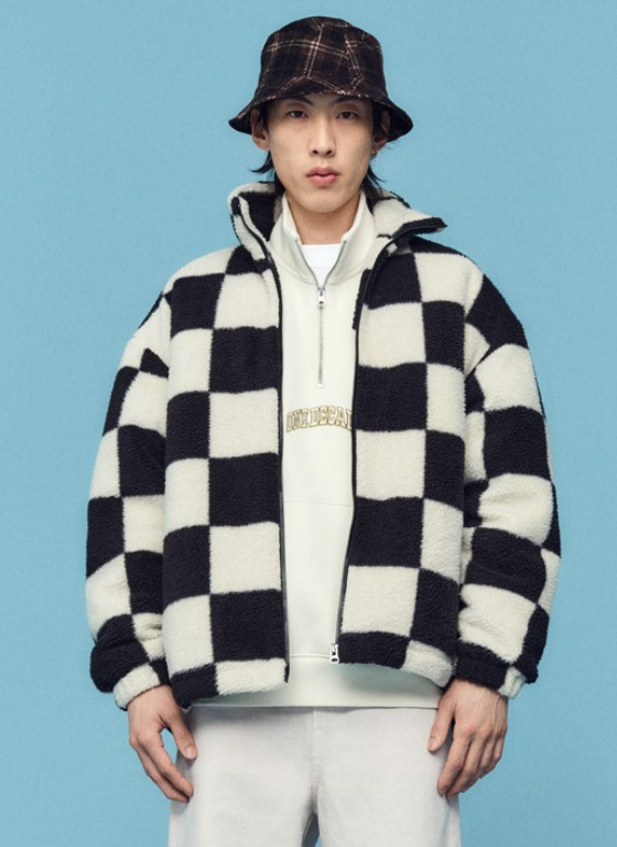 A man wearing a checkered H&M fleece jacket with a plaid bucket hat