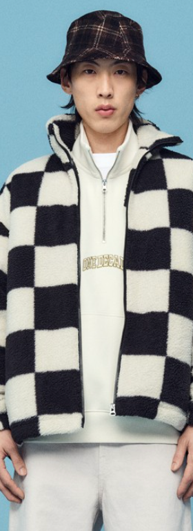 A man wearing a checkered H&M fleece jacket with a plaid bucket hat