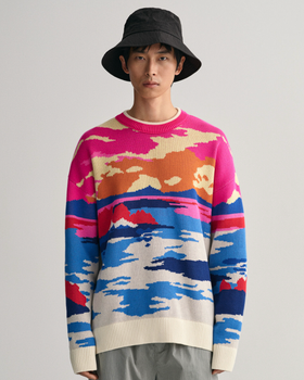 A man wearing a Gant sunset sweater, grey pants and a black bucket hat