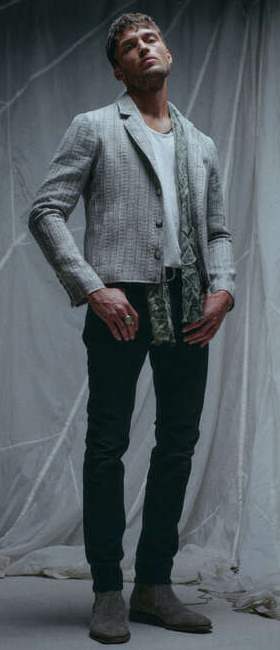 A man wearing a John Vavatos grey blazer with black pants