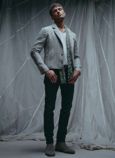A man wearing a John Vavatos grey blazer with black pants