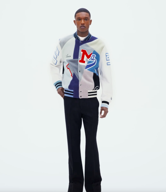 A man wearing an Amiri coaches jacket with black pants