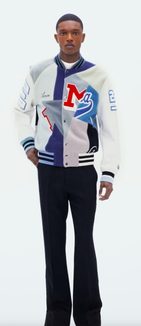 A man wearing an Amiri coaches jacket with black pants