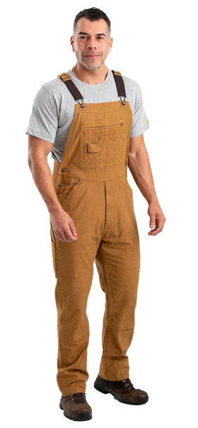 A man wearing brown workwear overalls by Berne Apparel