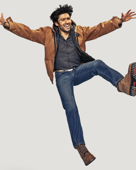 A man jumping in a brown Red Kap jacket and work boots