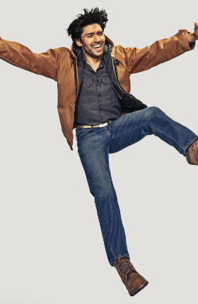 A man jumping in a brown Red Kap jacket and work boots