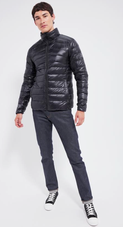 A man wearing a slim Pyrenex Puff black jacket with slim-fit jeans