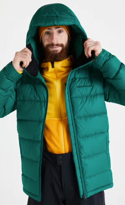 A man wearing a green puffy winter jacket along with a bright yellow fleece underneath