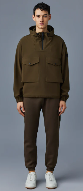 A man wearing a Mackage winter coat in olve green with sweatpants and white shoes