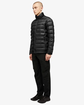 A man wearing a black Quartz Co. puffy jacket along with black pants and shoes