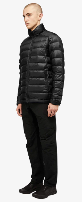 A man wearing a black Quartz Co. puffy jacket along with black pants and shoes