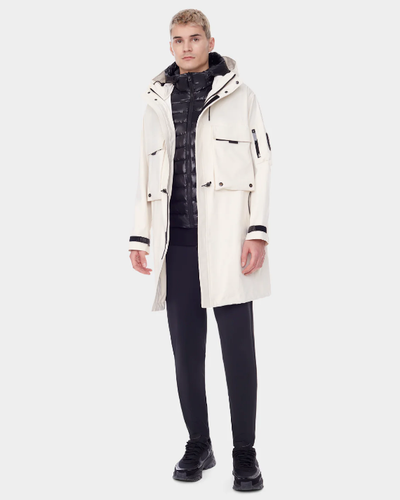 A man wearing a RudSak white winter jacket with a black puffy jacket underneath