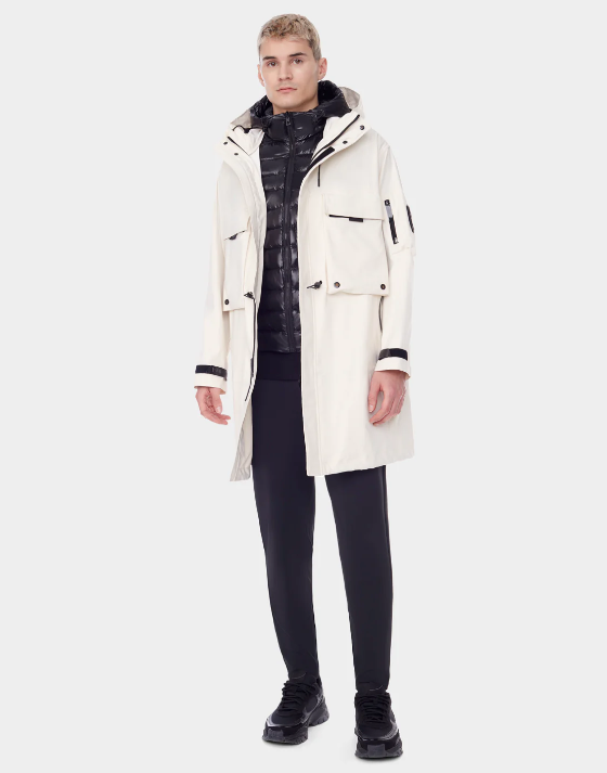 A man wearing a RudSak white winter jacket with a black puffy jacket underneath
