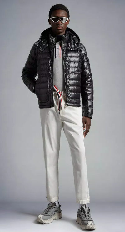 A man wearing a futuristic Moncler outfit featuring the patented puffy black jacket