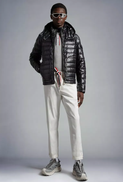 A man wearing a futuristic Moncler outfit featuring the patented puffy black jacket