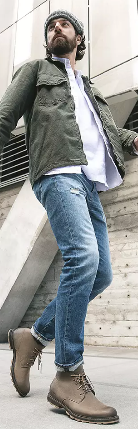 A close up of a man wearing brown Frye boots