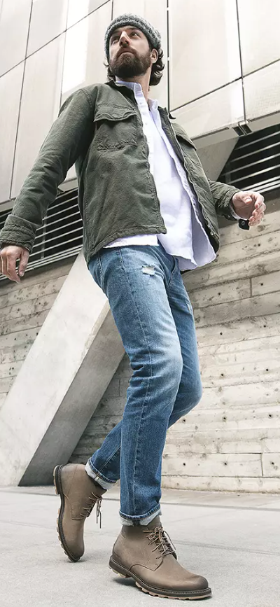 A close up of a man wearing brown Frye boots