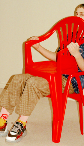 A man sitting wearing socks with a red lawn chair design on them