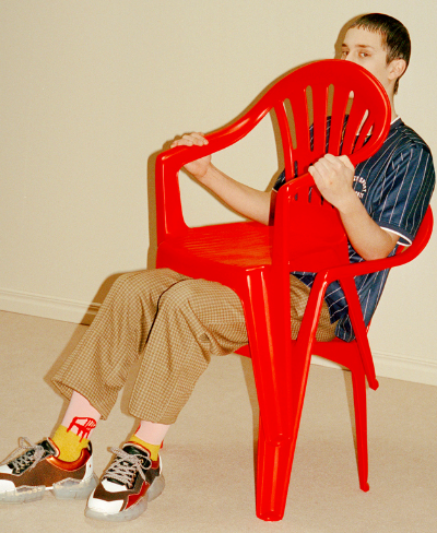 A man sitting wearing socks with a red lawn chair design on them