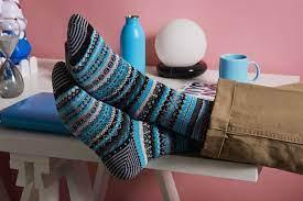 A close up of feet with colorful, patterned Chup socks on