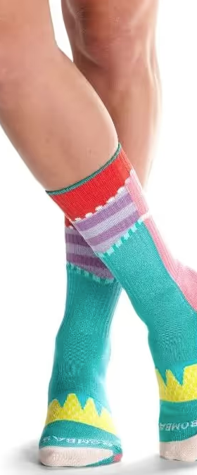 A close up of a colorful pair of bombas socks on feet