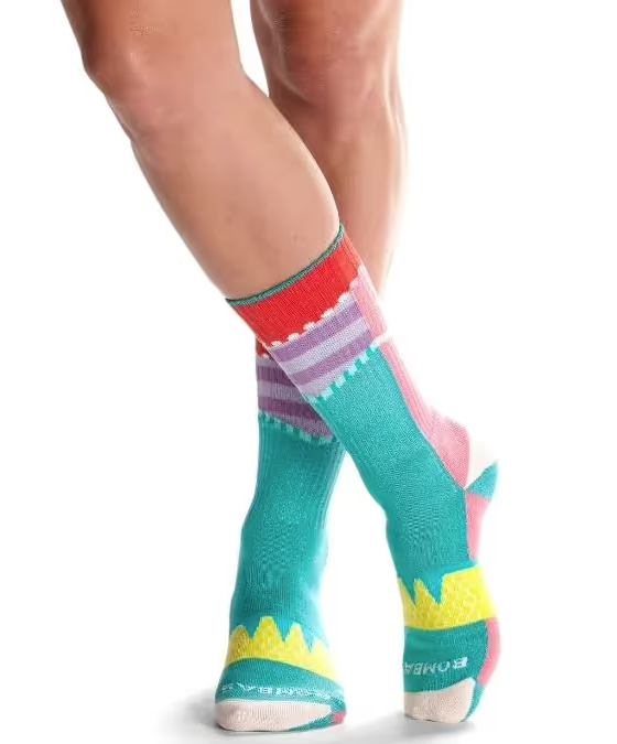 A close up of a colorful pair of bombas socks on feet