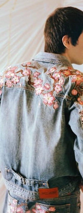 A man wearing a Evisu denim jacket with floral print over it