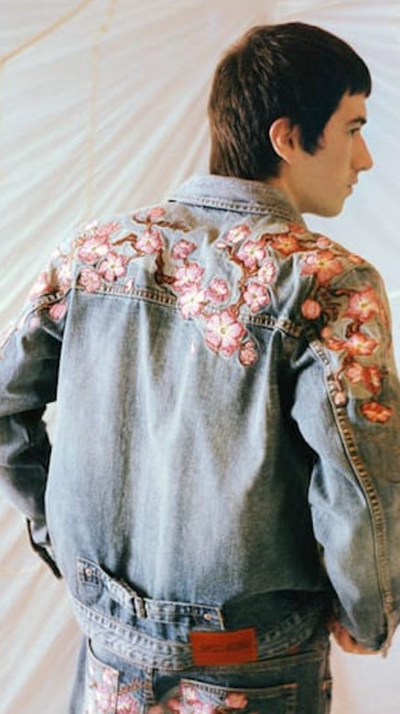 A man wearing a Evisu denim jacket with floral print over it